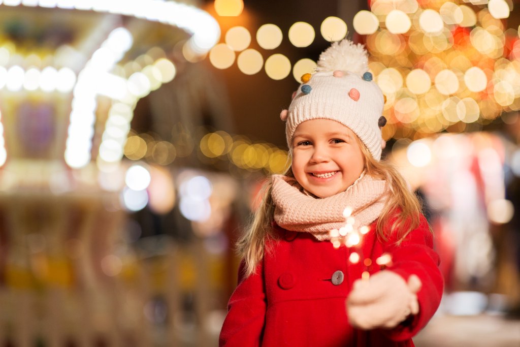 Happy girl from a Santa’s Village hotel with a sparkler at the Santa’s Village amusement park.